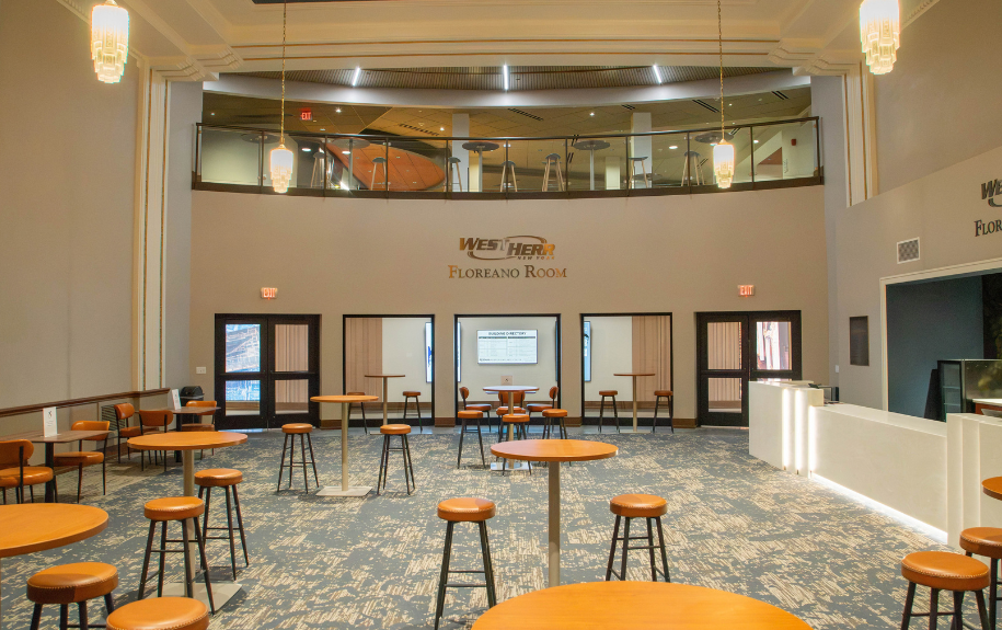 lounge with high-top tables looking at open upper-level lounge space.